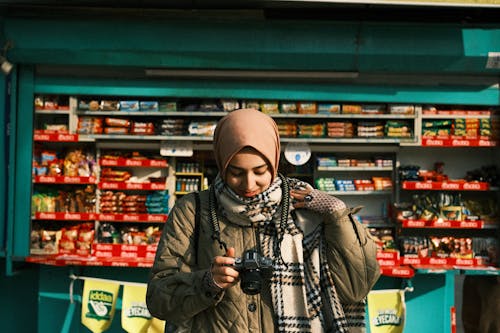 Woman in Green Jacket Holding a Camera