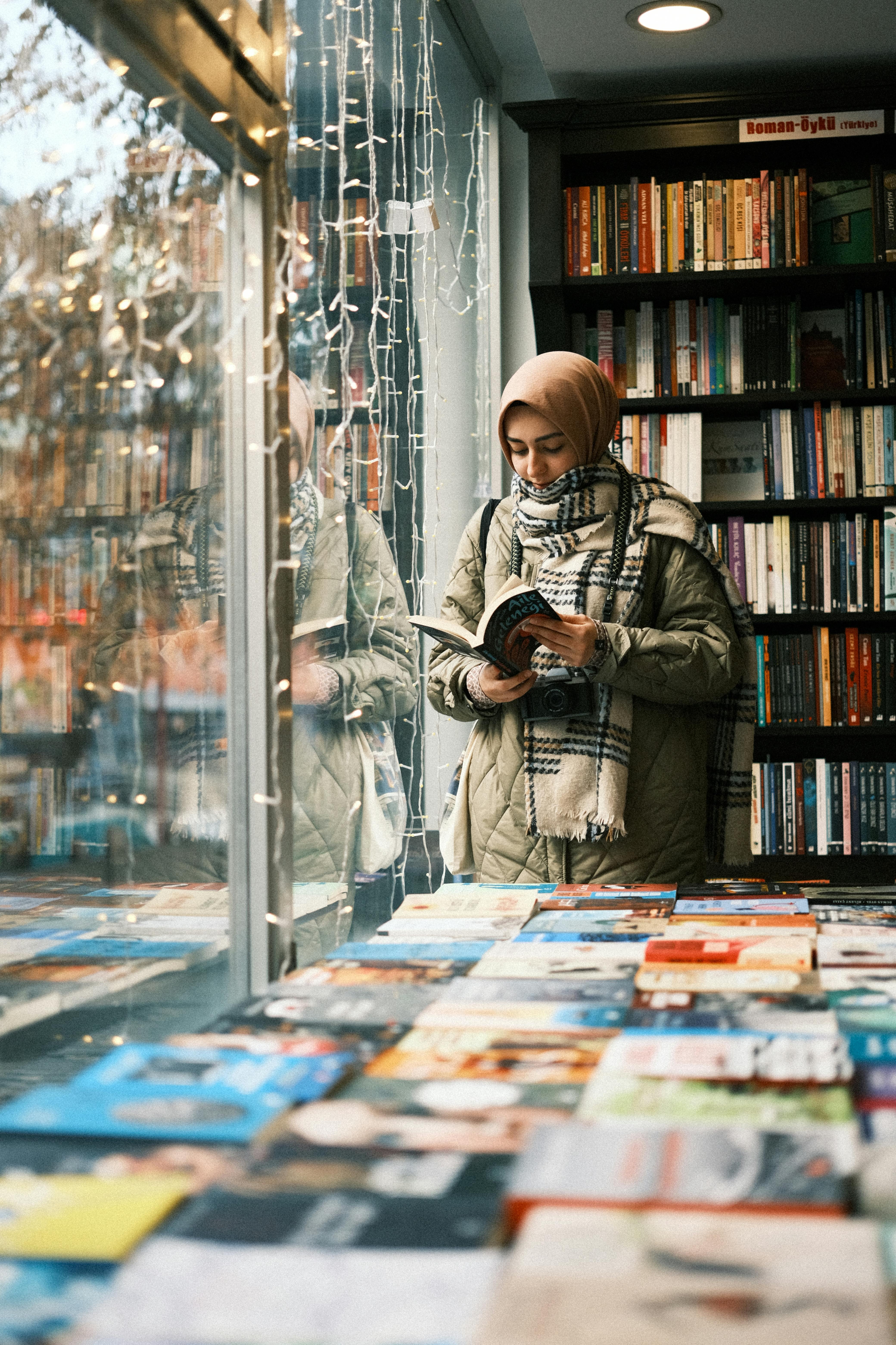 A woman reading a book in a bookshop. 