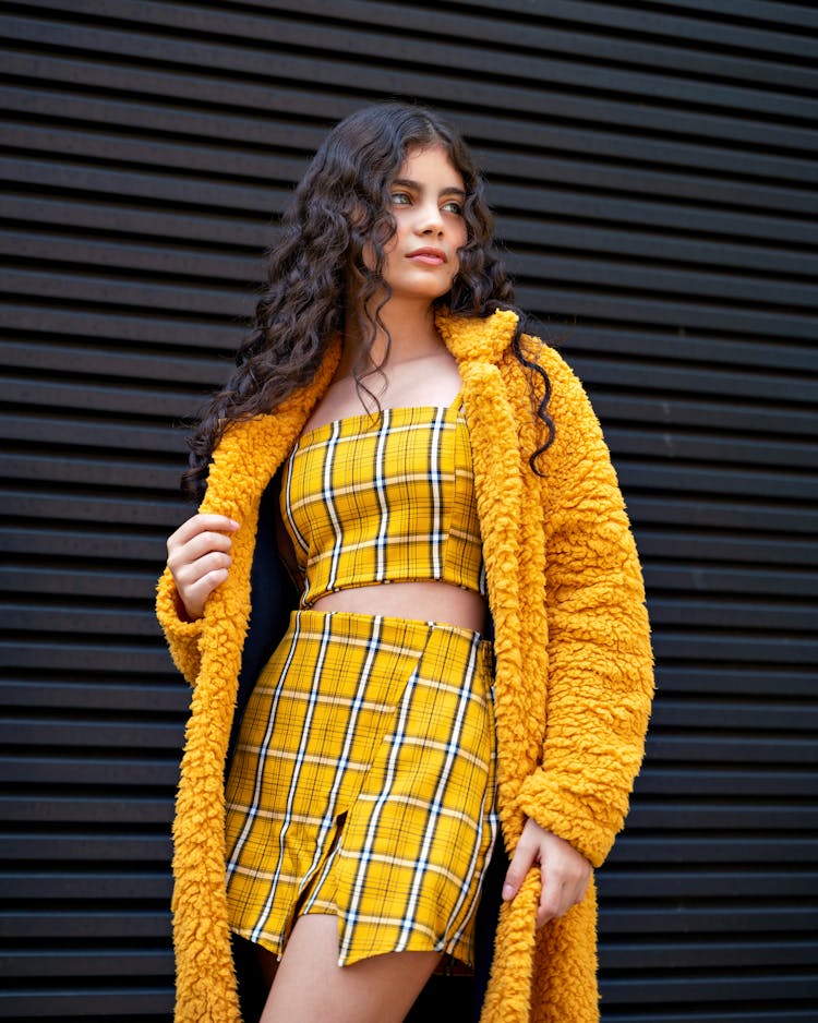 Woman In Stylish Outfit Posing At Wall Background