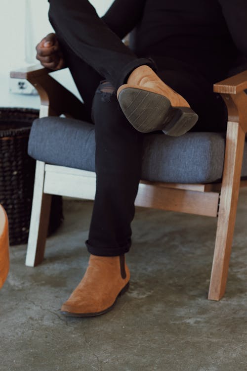 Legs and Shoes of Person Sitting on Armchair