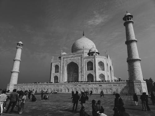 Grayscale Photo of People Standing Near the Mosque