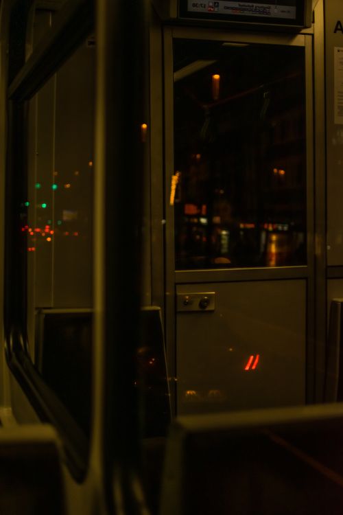 Free Urban nighttime scene inside a tram, capturing dimly lit interior and city lights outside. Stock Photo