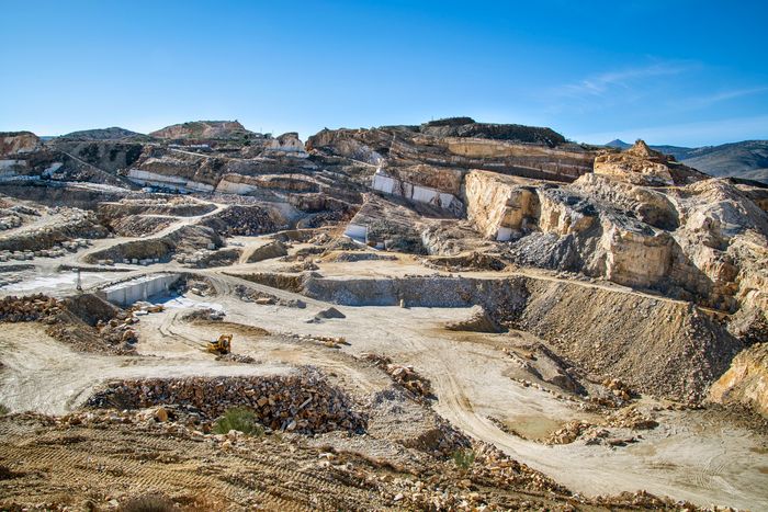 Terraced benches of an open stone quarry — photo by Enrique on Pexels