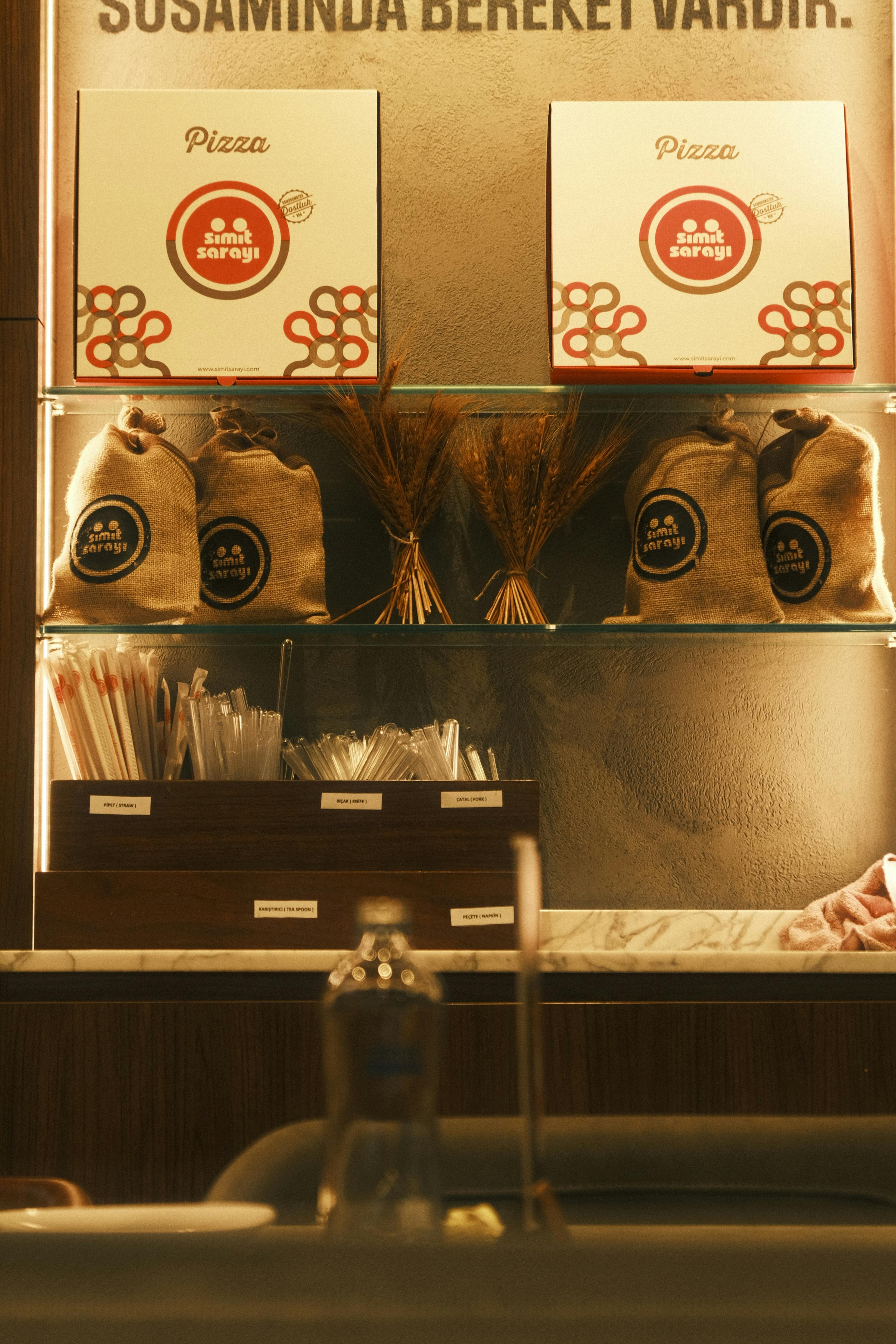 A Shelf with Flour Bags and Pizza Boxes in a Pizzeria · Free Stock Photo