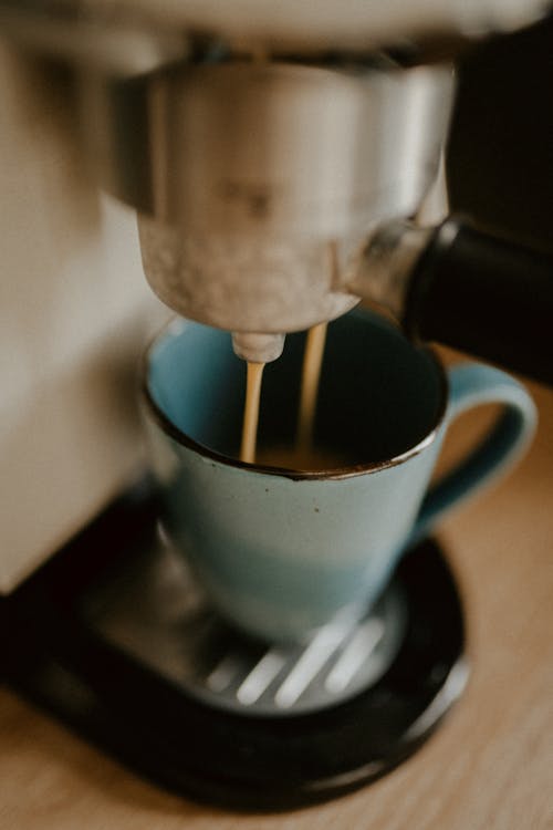 Pouring of Espresso on a Small Coffee Cup 
