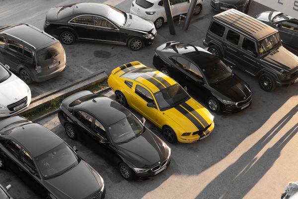 Cars parked in an open lot on a bright morning