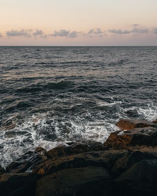 Free Scenic ocean view with waves crashing on rocks at sunset, capturing the raw beauty of nature. Stock Photo