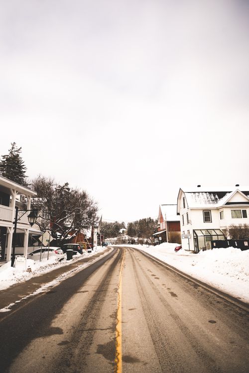 Free A quiet, snow-covered residential street with houses on a winter day. Stock Photo