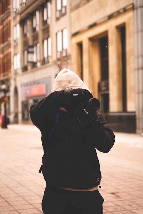 Person Wearing Jacket Taking Photo with a Camera