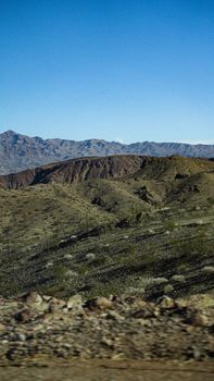 A breathtaking view of a desert mountain range under a clear blue sky, capturing the essence of rugged wilderness.