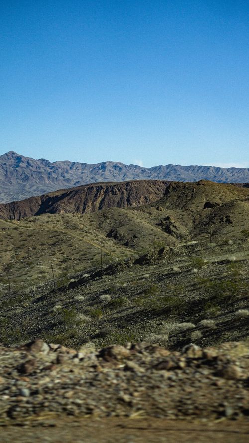 Free A breathtaking view of a desert mountain range under a clear blue sky, capturing the essence of rugged wilderness. Stock Photo