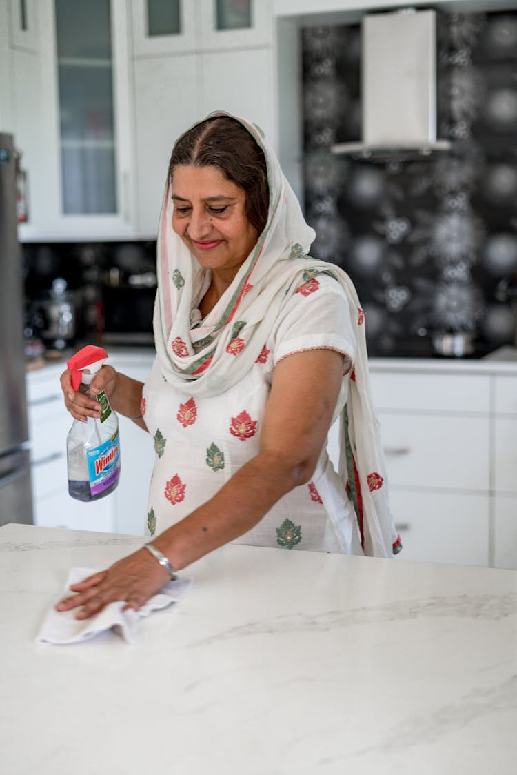 Woman Cleaning A Kitchen Counter