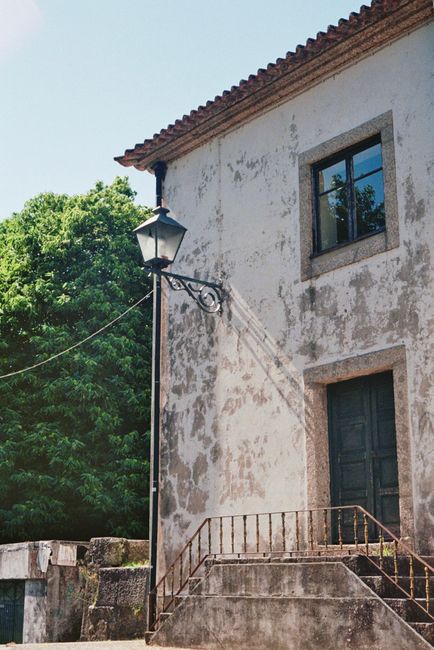 Rustic house exterior with a classic street lamp and lush greenery. Perfect for urban exploration.