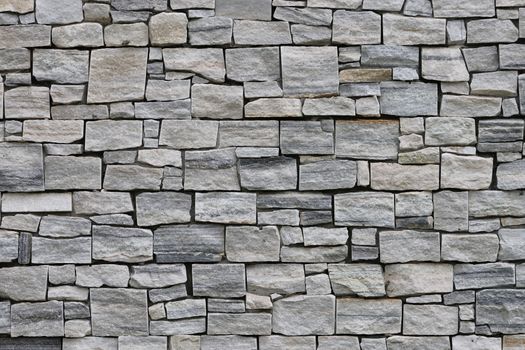 Detailed texture of a rustic stone wall, perfect for backgrounds or wallpaper.
