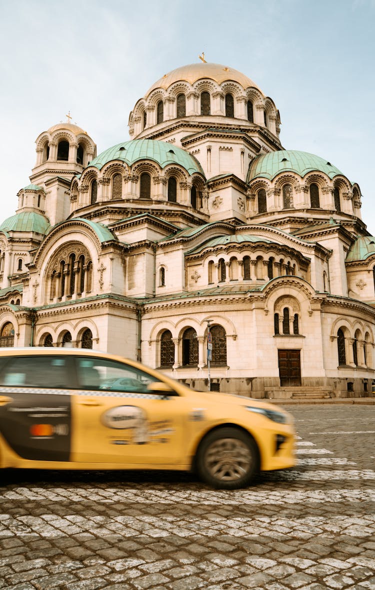 Yellow Taxi On Road Near Old Traditional Building