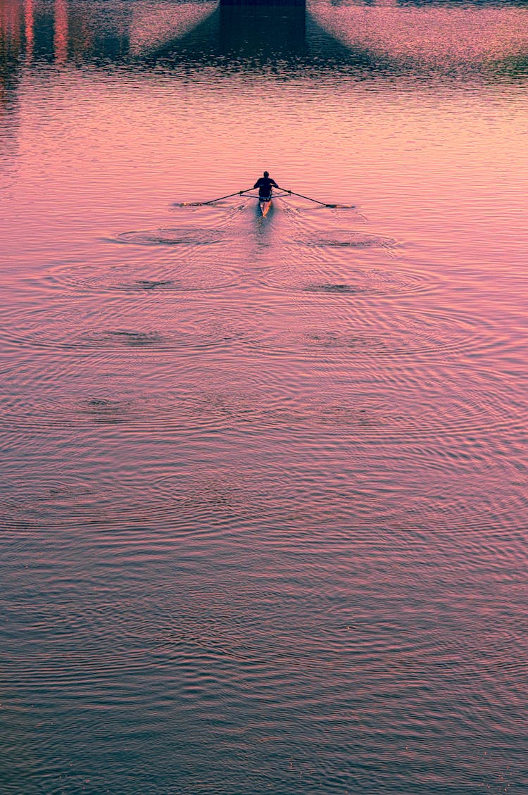 Boat Swimming On River At Sunset