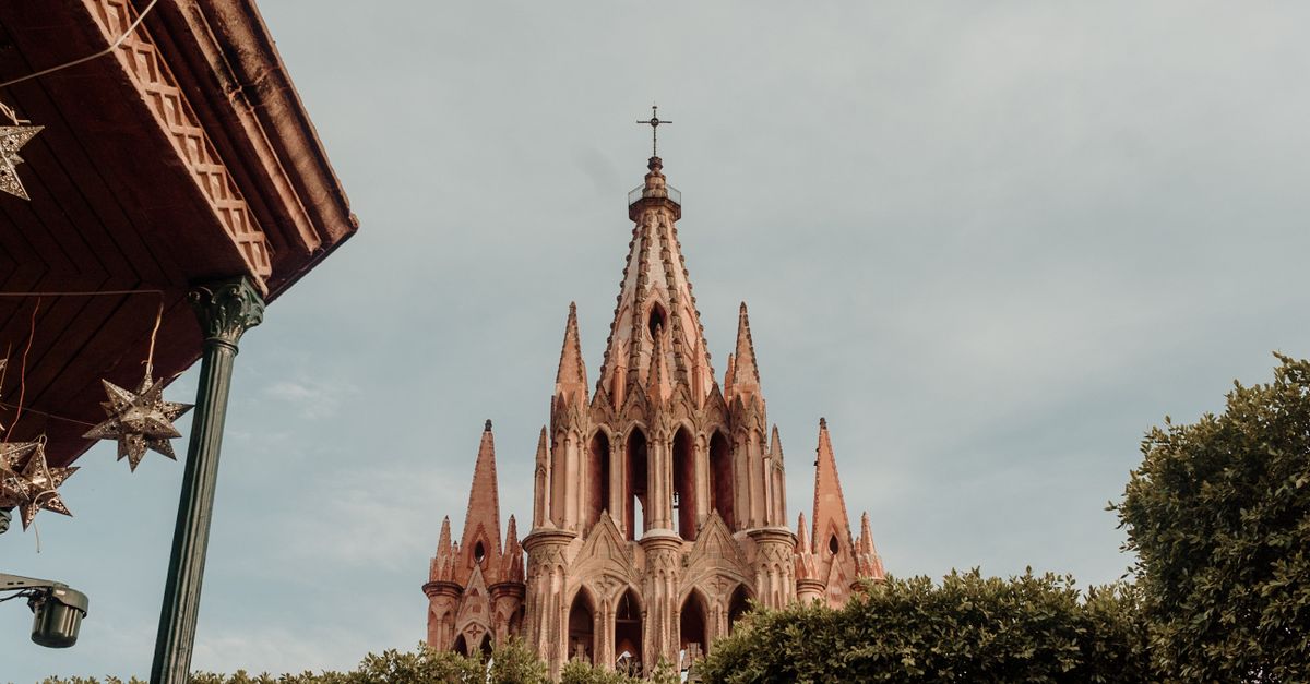 San Miguel de Allende colonial street with church dome and blooming jacaranda trees