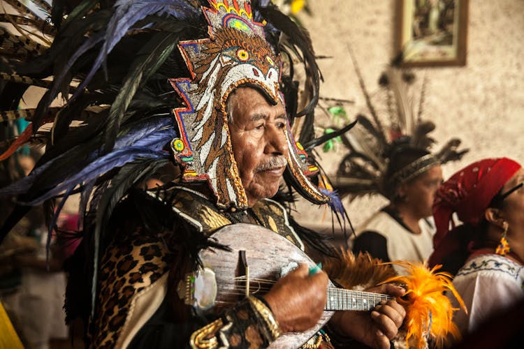 Old Man In Traditional Costume Playing Ukulele