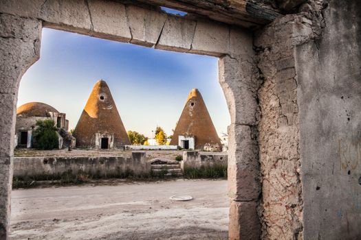 Explore ancient conical structures amidst ruins in San Felipe, Mexico with a clear sky backdrop.