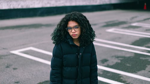 Woman in Jacket Posing on Empty Car Park