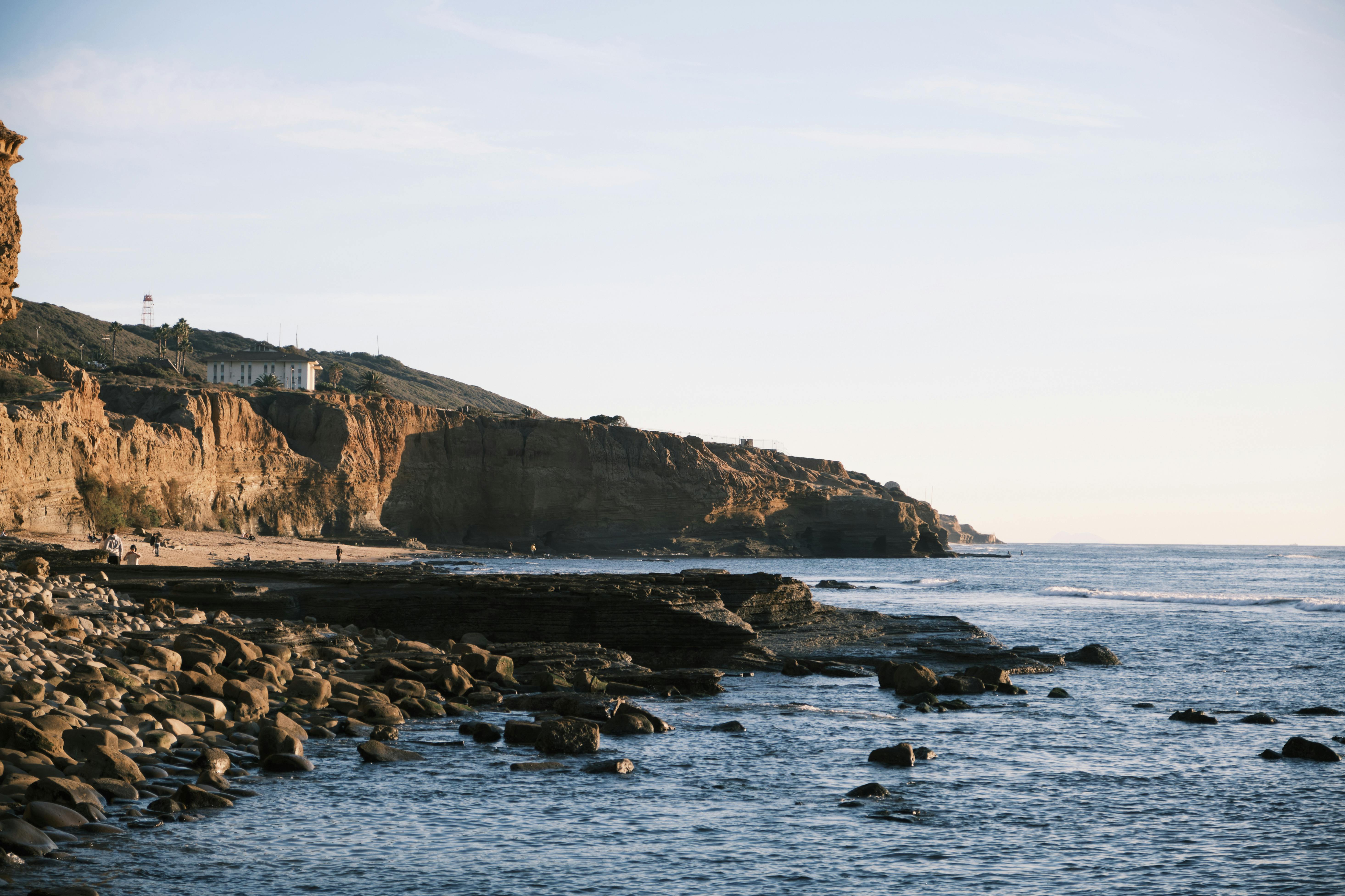 Scenic view of ocean waves hitting rocky shoreline with imposing cliffs