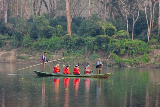 Group enjoying guided canoe ride on a calm forest lake with life jackets