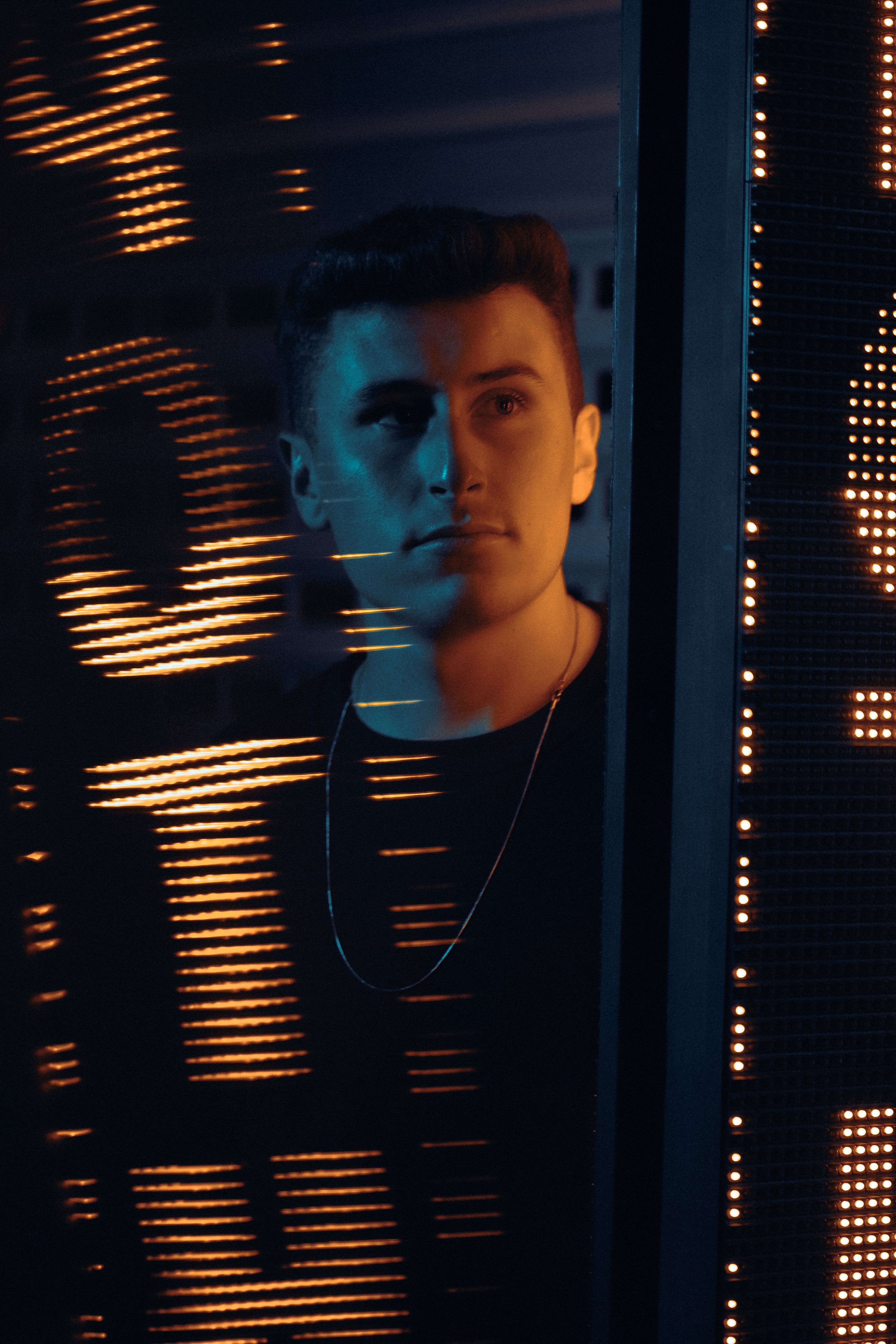 A dramatic portrait of a man illuminated by neon lights, creating an atmospheric vibe.