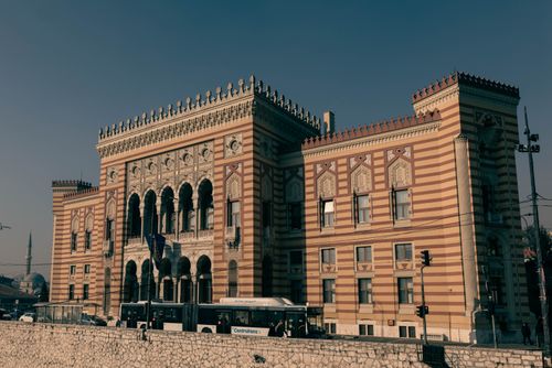 Free The Vijecnica Sarajevo, an iconic architectural landmark featuring intricate designs and stripes under a clear sky. Stock Photo