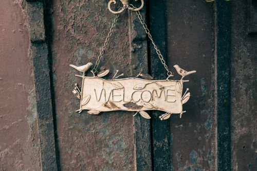 Free A rustic metal welcome sign with bird decorations, perfect for home decor or entryways. Stock Photo