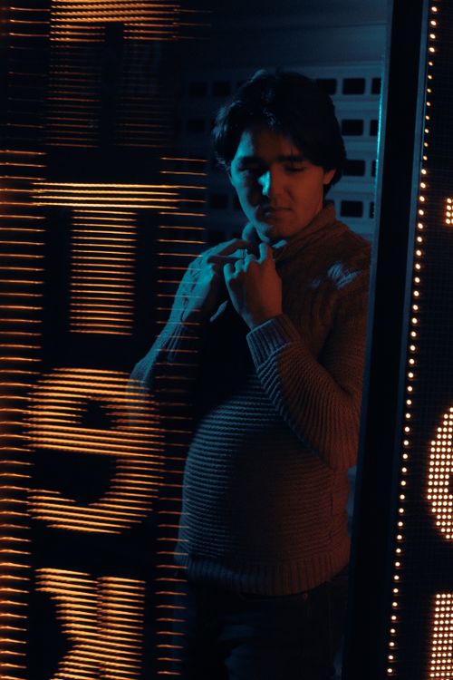 Free Dramatic portrait of a man in neon lighting, creating a moody and thoughtful atmosphere. Stock Photo