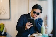 Man Wearing Grey Sunglasses Holding Black Tablet