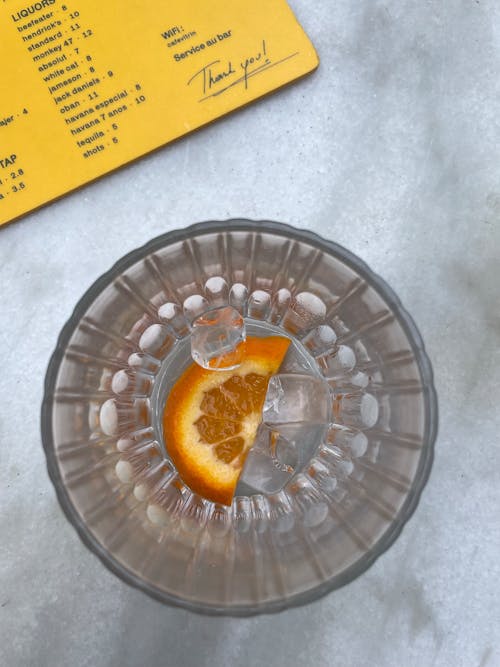 Slice of Orange and Ice Cubes in a Glass of Water