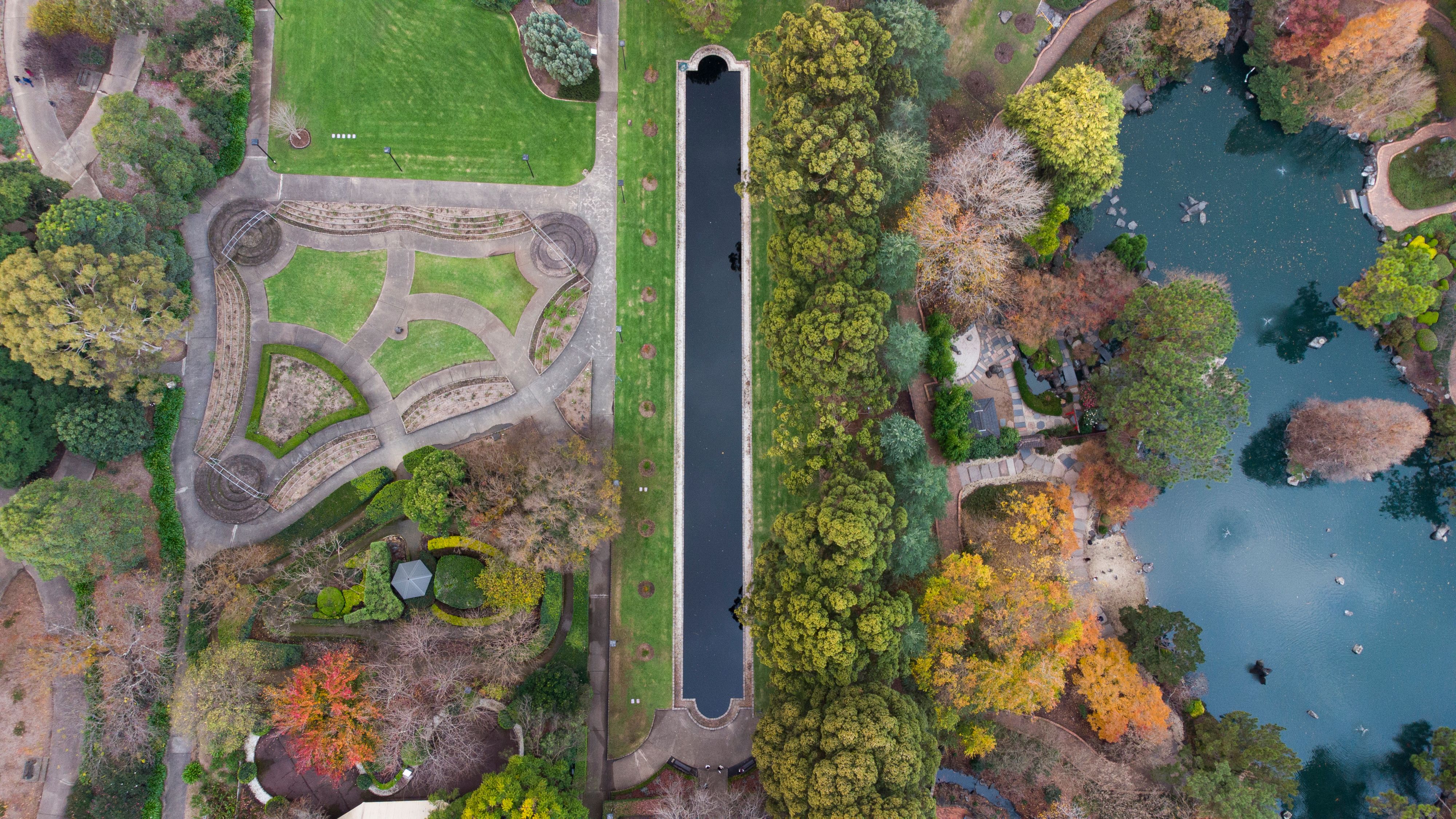 A stunning aerial shot of Auburn Botanical Gardens showcasing lush greenery and ponds in autumn colors.
