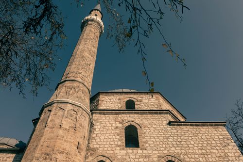 Free Low angle view of a mosque minaret in Sarajevo with clear blue sky. Stock Photo