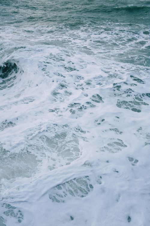 Free A captivating vertical shot of dynamic ocean waves crashing with frothy foam, perfect for nature enthusiasts. Stock Photo