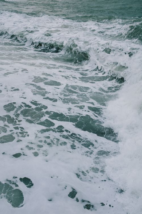Free An invigorating view of ocean waves crashing onto the shore, showcasing nature's power and beauty. Stock Photo