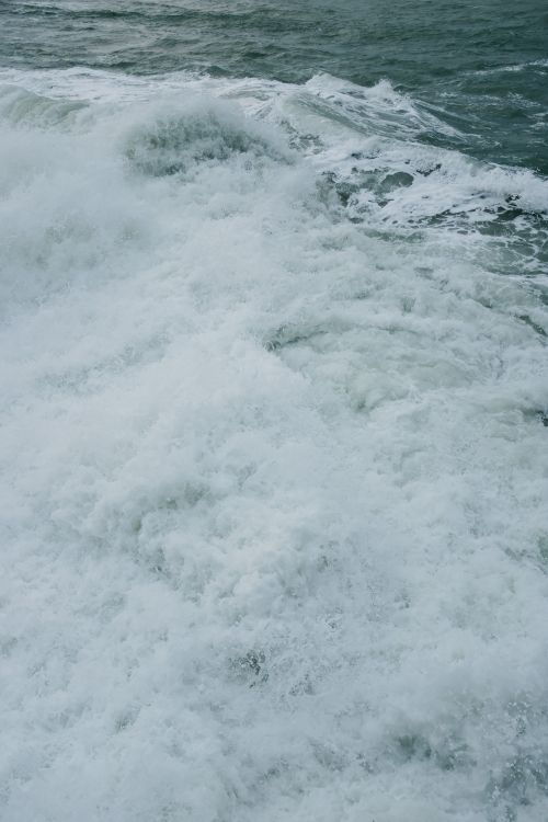 Free Powerful ocean waves splashing with foamy crests captured in a dynamic, close-up shot. Stock Photo