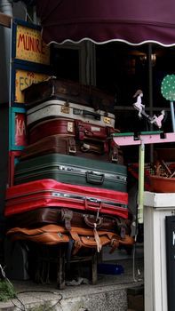 Colorful stack of vintage suitcases on a bustling İstanbul street market.