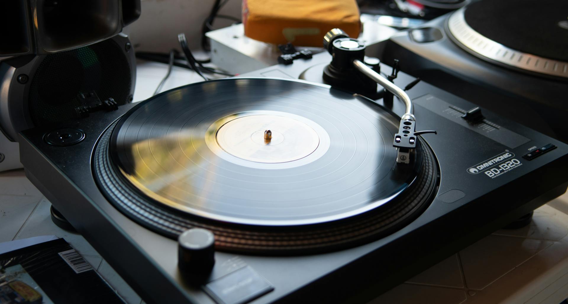 Close-up of a vintage turntable playing a vinyl record, showcasing retro music equipment.