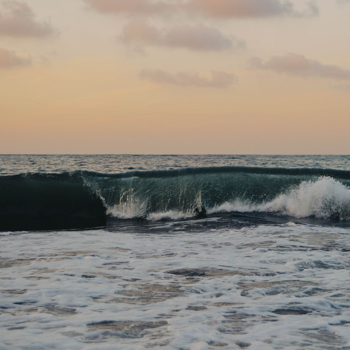 Captivating sunset over Sayulita Beach, Mexico with crashing waves and colorful sky.