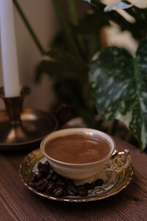 Free A stylish cup of coffee with beans in an elegant setting, perfect for cozy ambience. Stock Photo