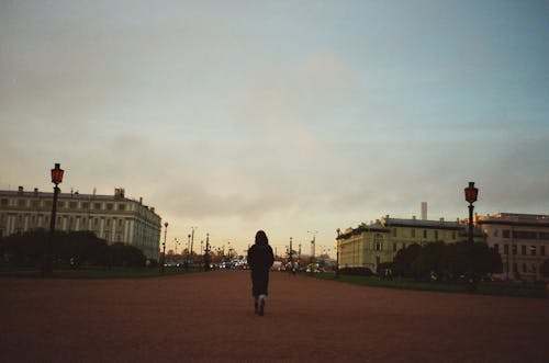 Woman Walking Towards City