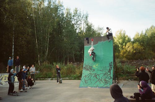 бесплатная Люди смотрят, как человек катается на коньках на зеленой рампе Стоковое фото