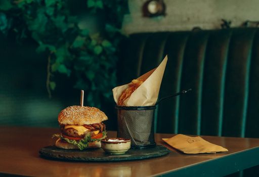 A delicious gourmet cheeseburger paired with crispy fries in a stylish restaurant setting, perfect for food enthusiasts.