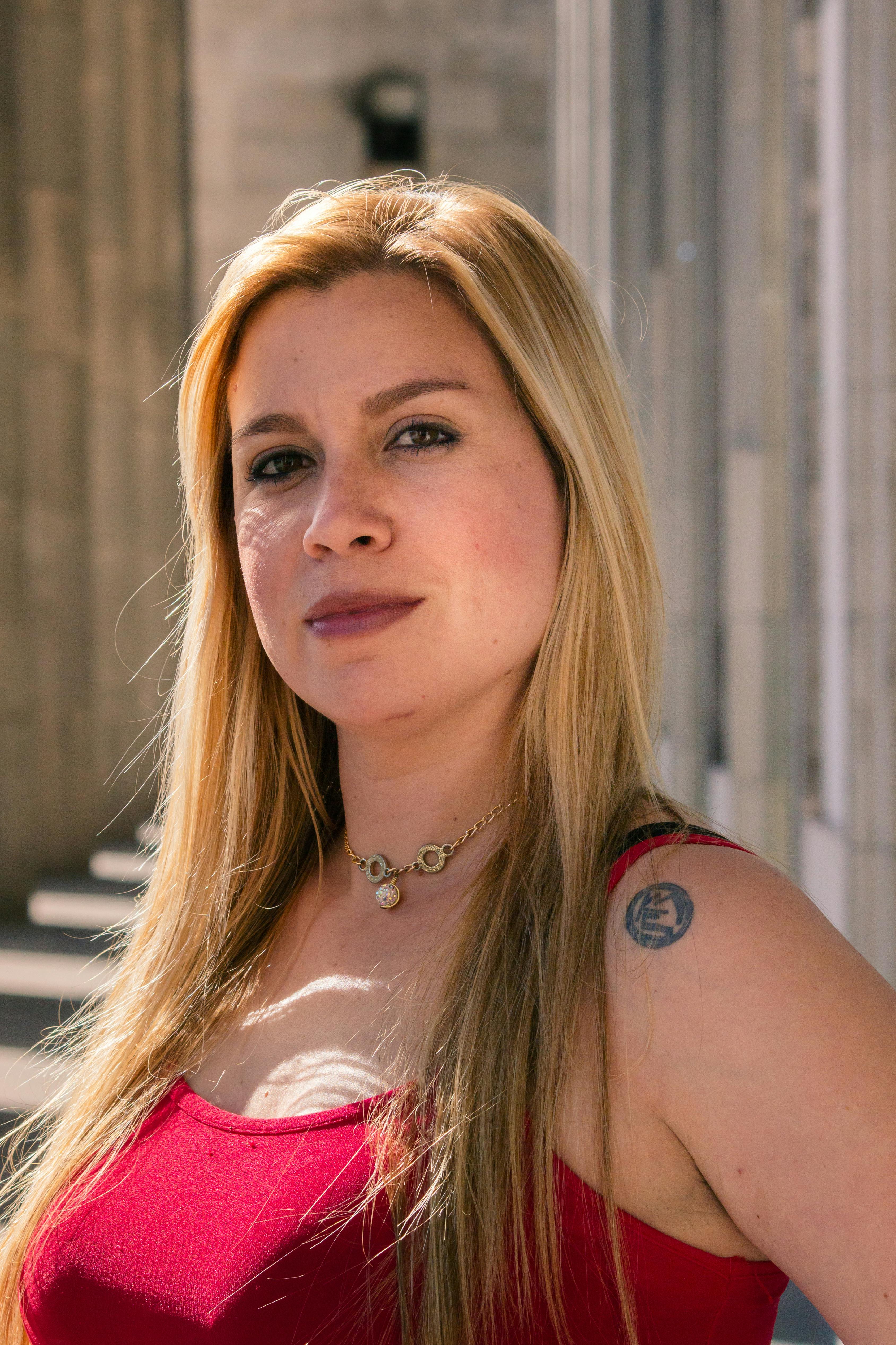 Portrait of a confident woman in Buenos Aires, showcasing her blonde hair and tattoo.