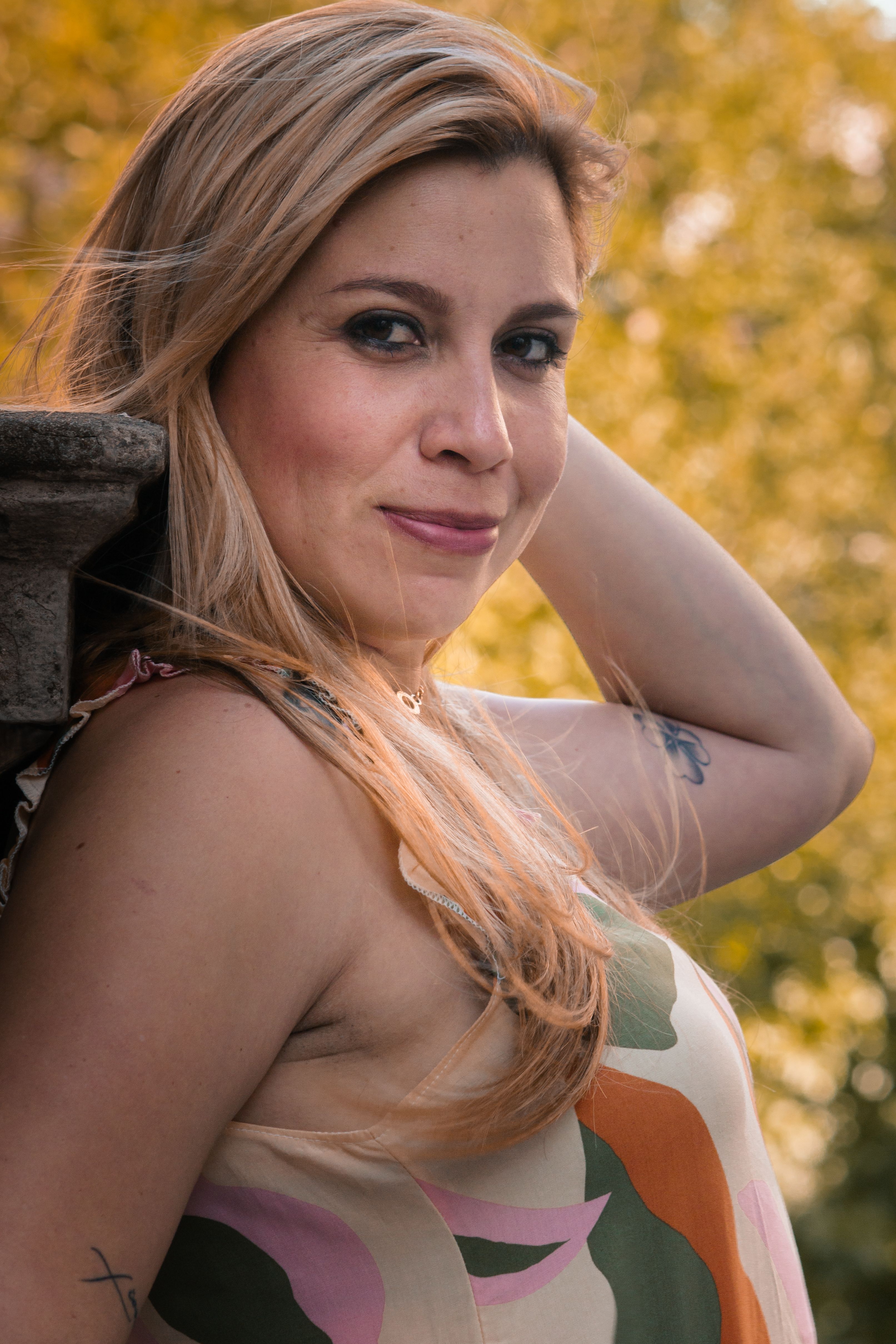 A woman with blond hair poses outdoors in Buenos Aires, exuding confidence.