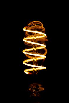 A warm, glowing spiral LED light shines against a dark backdrop, creating a modern aesthetic.