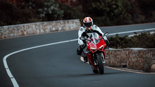 Man Riding on Red Motorbike on a Street 