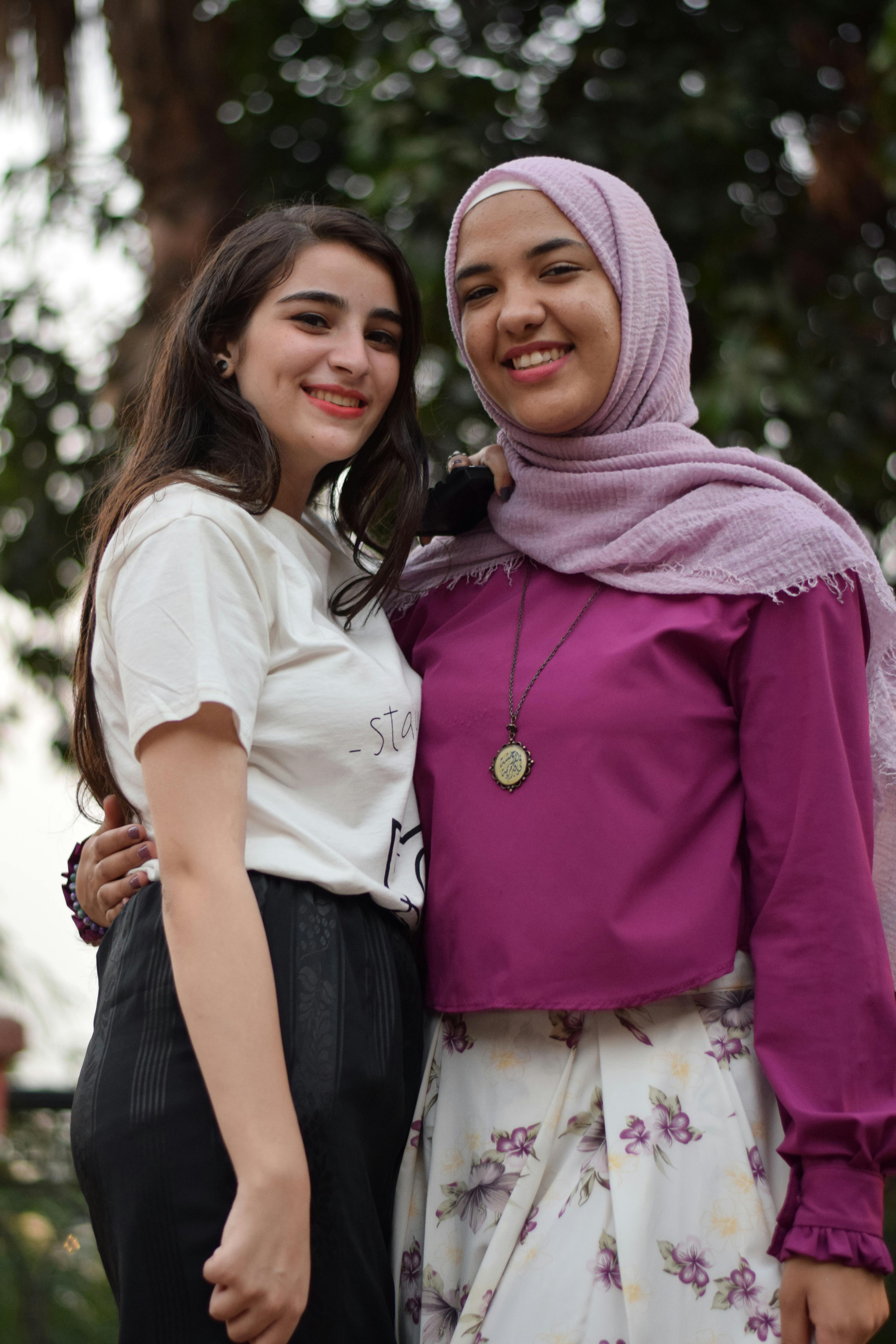 woman taking photo with another woman near trees