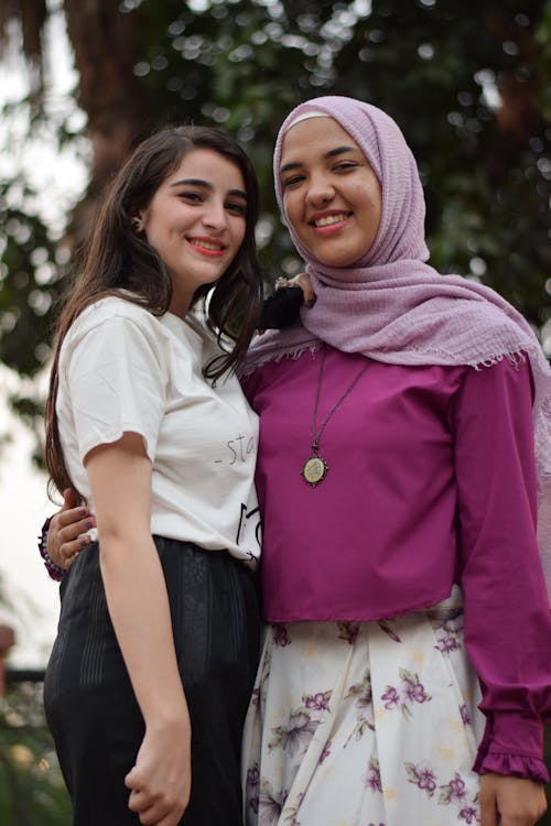 Woman Taking Photo With Another Woman Near Trees